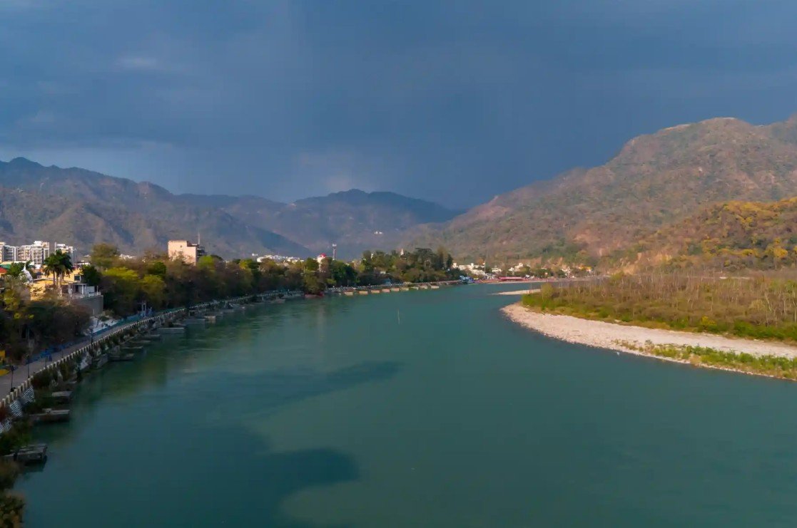The Divine Ganga flowing past the forested Himalayan foothills near Rishikesh